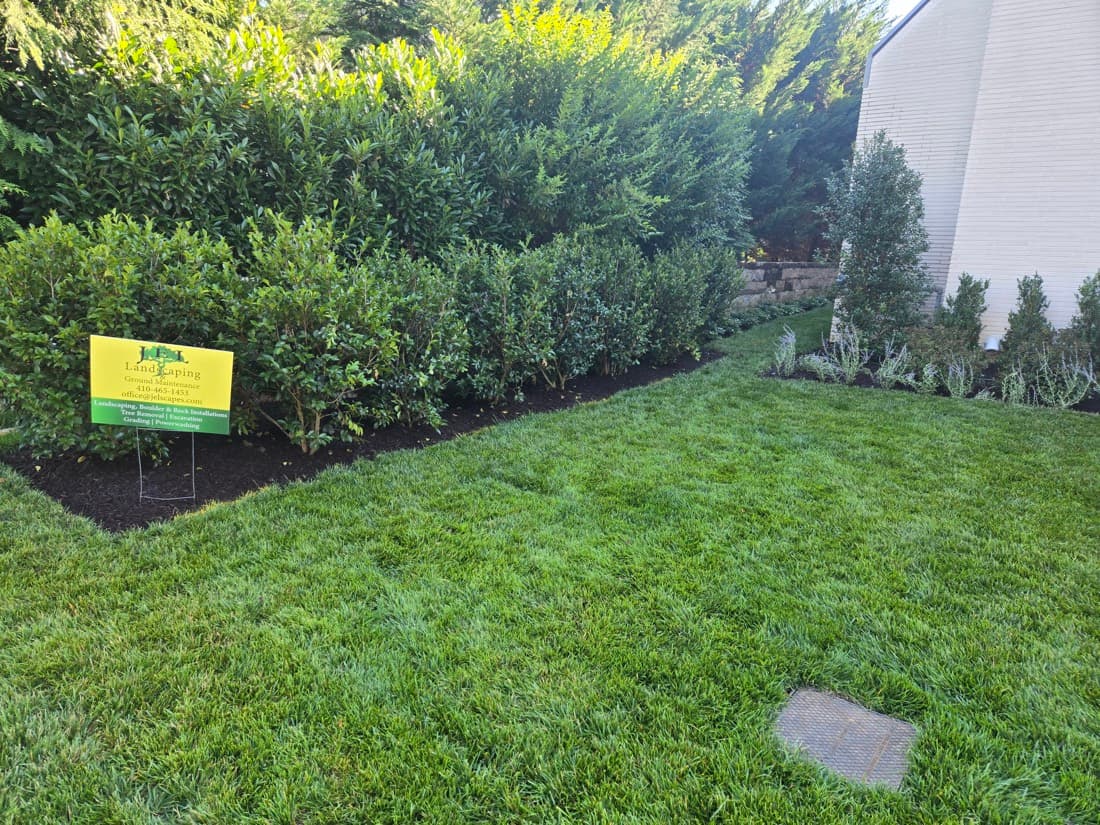 A JEL Landscaping yard sign on a freshly manicured, fully maintained property